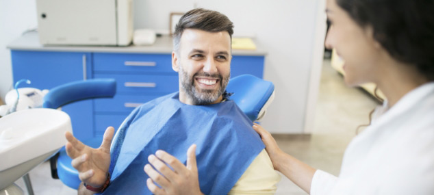 happy-man-dental-patient-speaking-with-dentist