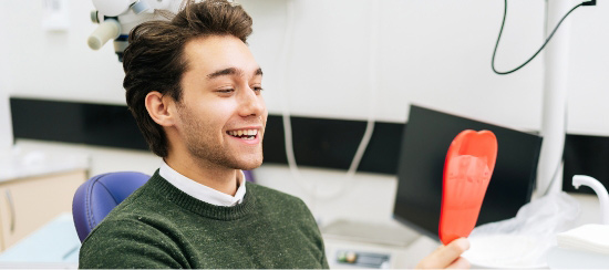 smiling-man-looking-at-himself-in-mirror