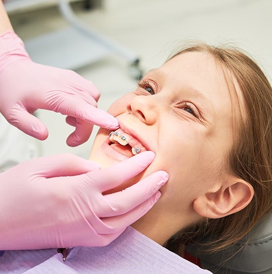 Child smiling during an Invisalign consultation with a dentist